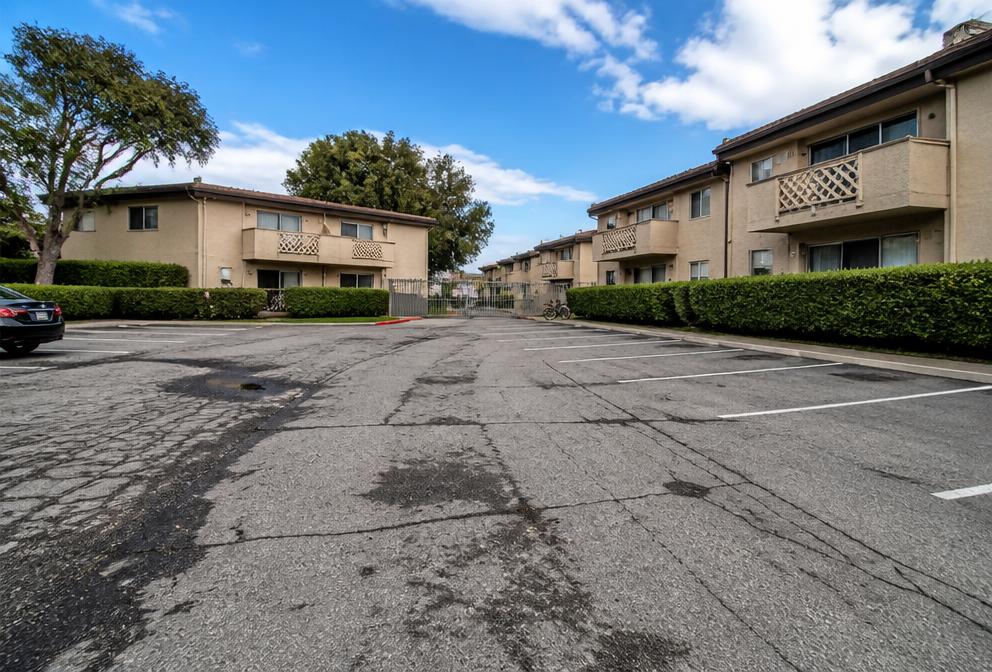 Cracked asphalt parking lot in front of apartment buildings